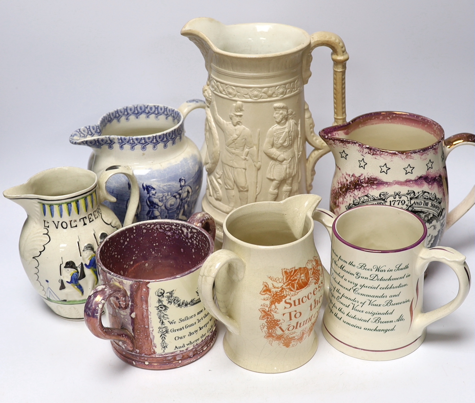 Seven military and naval themed jugs including a Leeds creamware jug 'Loyal Volunteers' inscribed 'L Volnteers' c.1803, an early 19th century success to the volunteers jug, a Sunderland pink splash lustre loving cup etc.